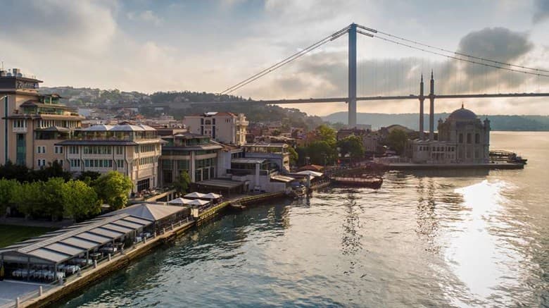 Guests dining on the Starboard restaurant terrace at Radisson Blu Bosphorus, directly beneath the suspension cables of the Bosphorus Bridge.