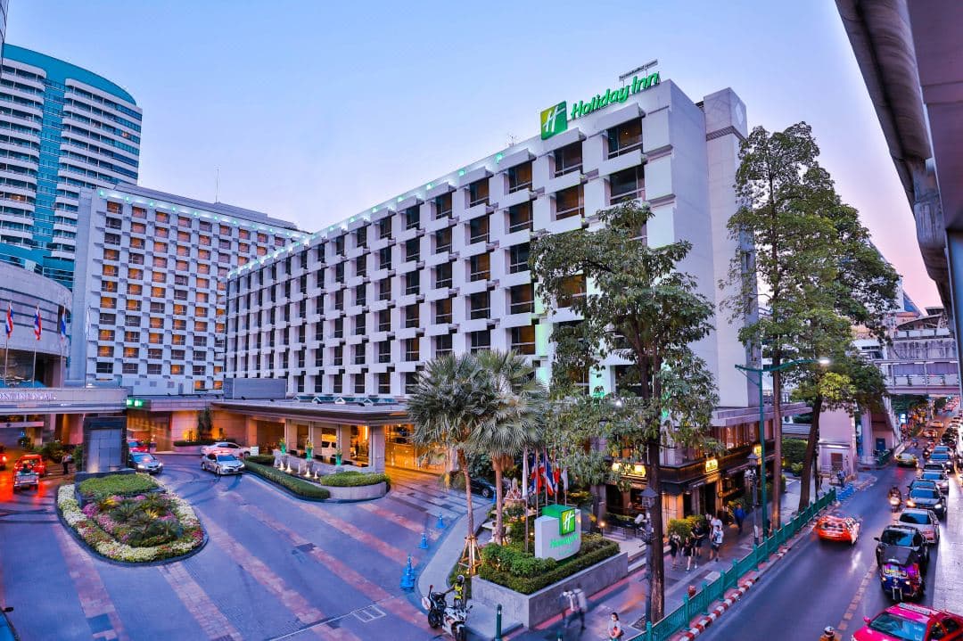Holiday Inn Bangkok outdoor pool deck featuring a 12.5m lap pool with a skyline backdrop of Ratchaprasong district skyscrapers and Central World.