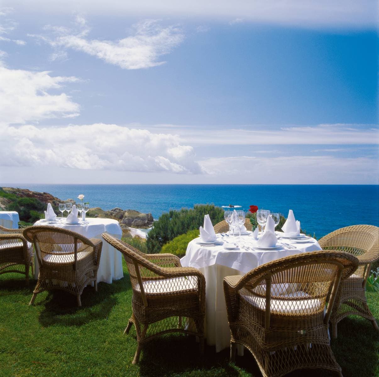 Vila Joya's Moorish arched terrace at sunset overlooking the Atlantic Ocean.