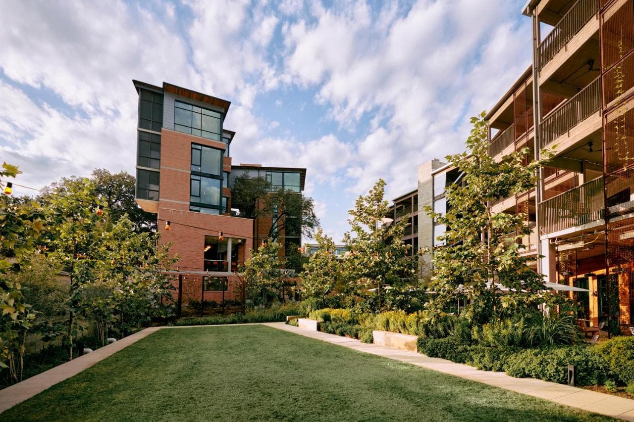 Hotel Magdalena's sunken swimming pool surrounded by native Texas landscaping and zig-zag timber breezeways.