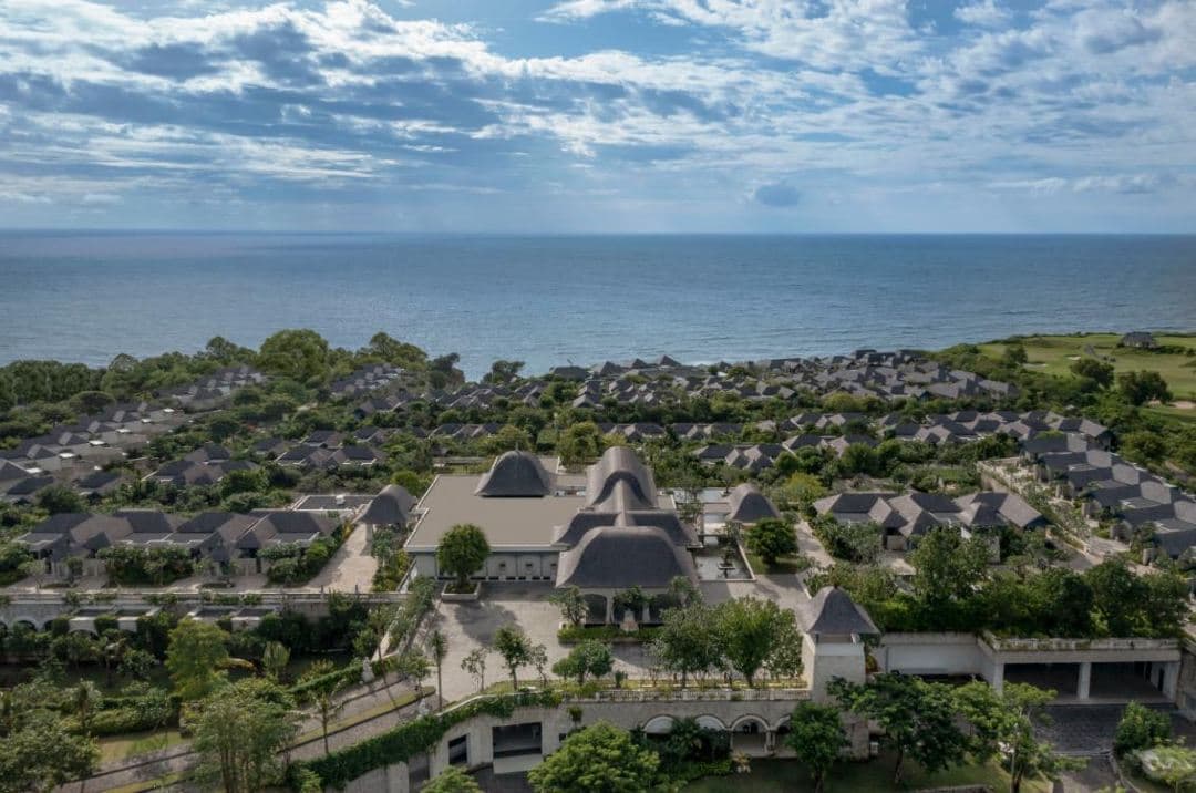 The imposing stone entrance of Jumeirah Bali featuring Singa Ambara Raja statues and water features overlooking the Indian Ocean.