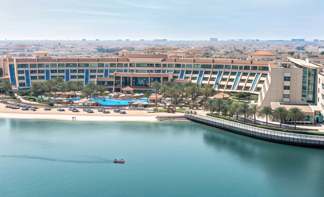 Infinity pool at Al Raha Beach Resort with the circular Aldar HQ building rising in the background.