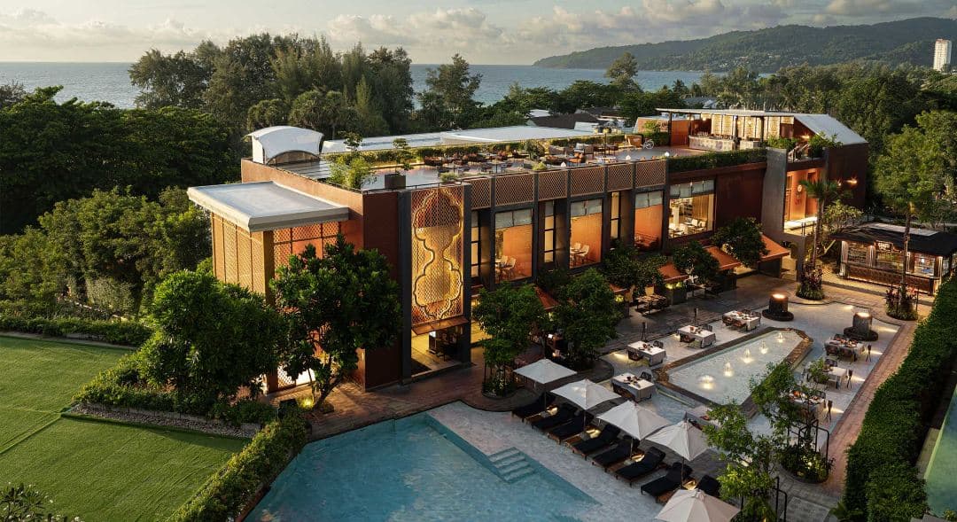 シノ・ポルトガル様式のコロニアルアーチと緑豊かな植物に囲まれた、Avista Grande Phuket Karonの見事な大理石のフリーフォームプール。