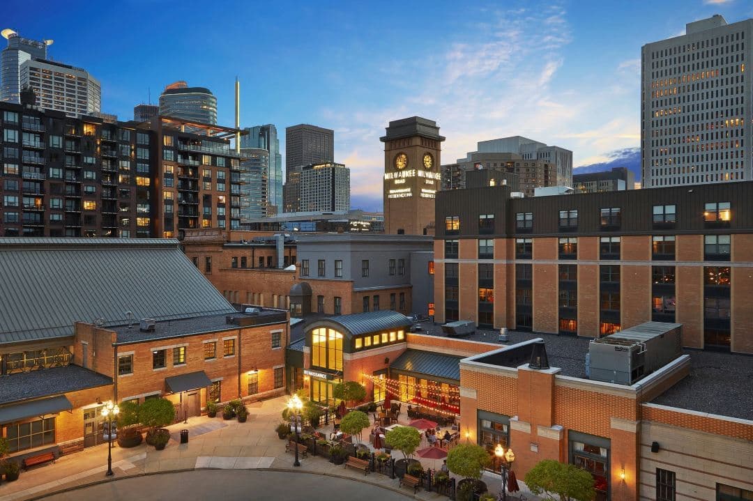 The Great Hall at The Renaissance Depot Minneapolis featuring soaring steel trusses, exposed yellow brick, and warm industrial lighting.