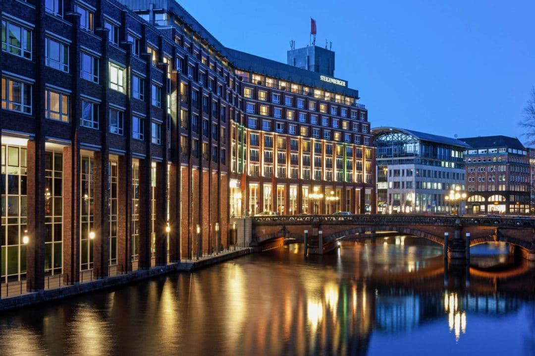 View from Steigenberger Hotel Hamburg showing the Alsterfleet canal and the yellow U-Bahn train crossing the historic viaduct.