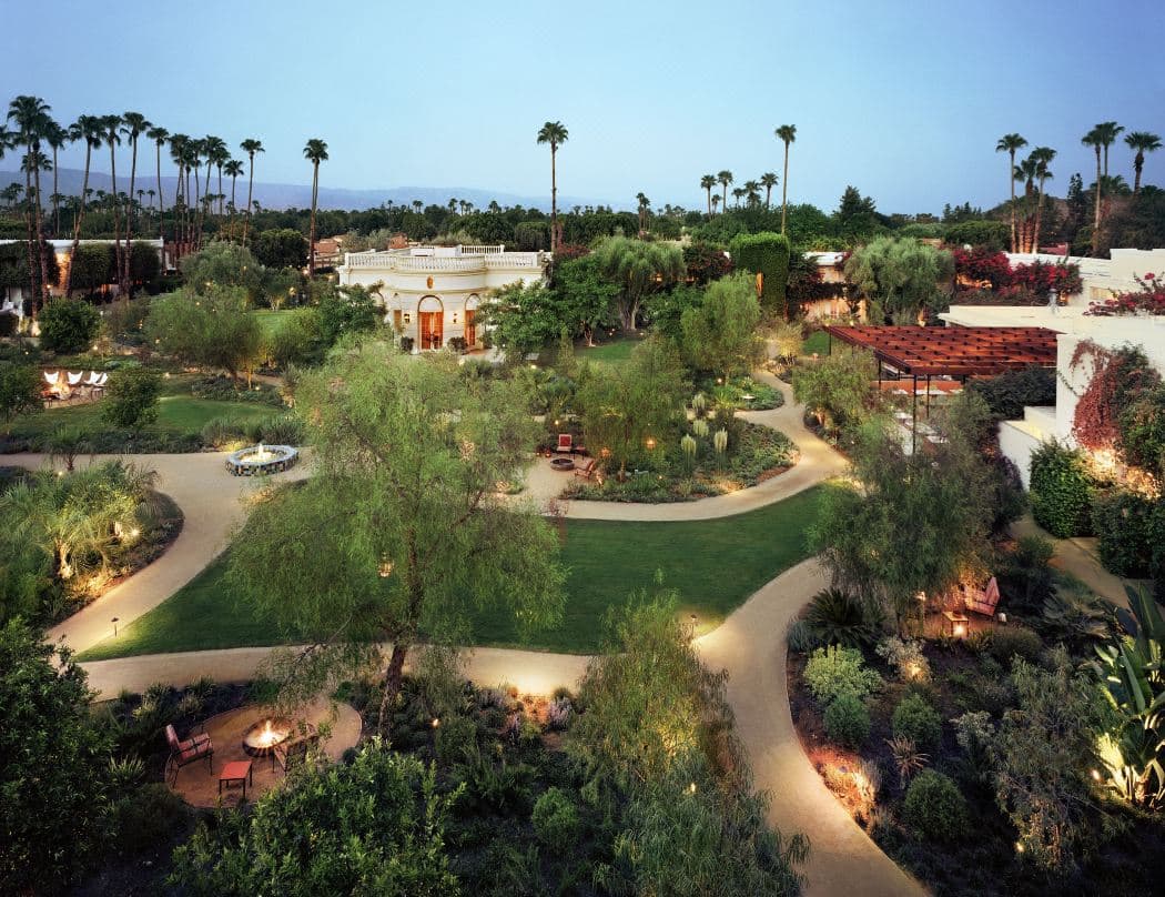 Parker Palm Springs 飯店標誌性的白色幾何磚牆外觀，搭配鮮豔的橙色雙開門與中世紀現代風格設計。