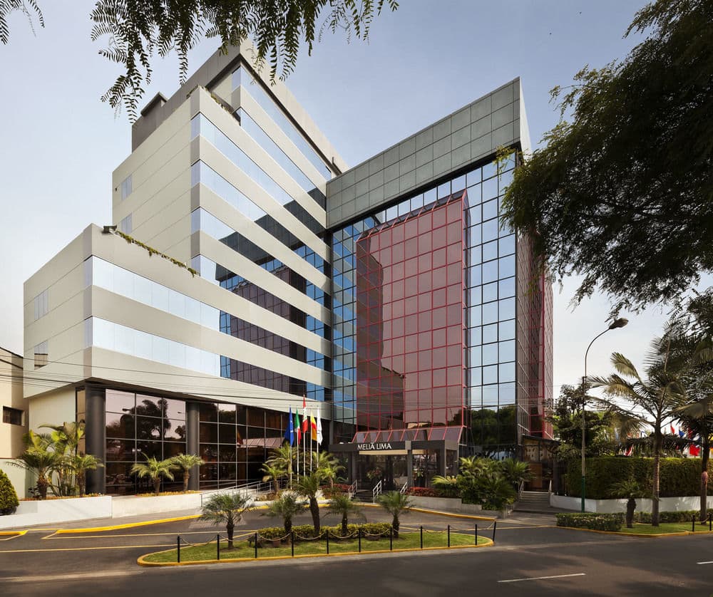 Meliá Lima exterior showing the modern mirrored facade reflecting the San Isidro skyline.