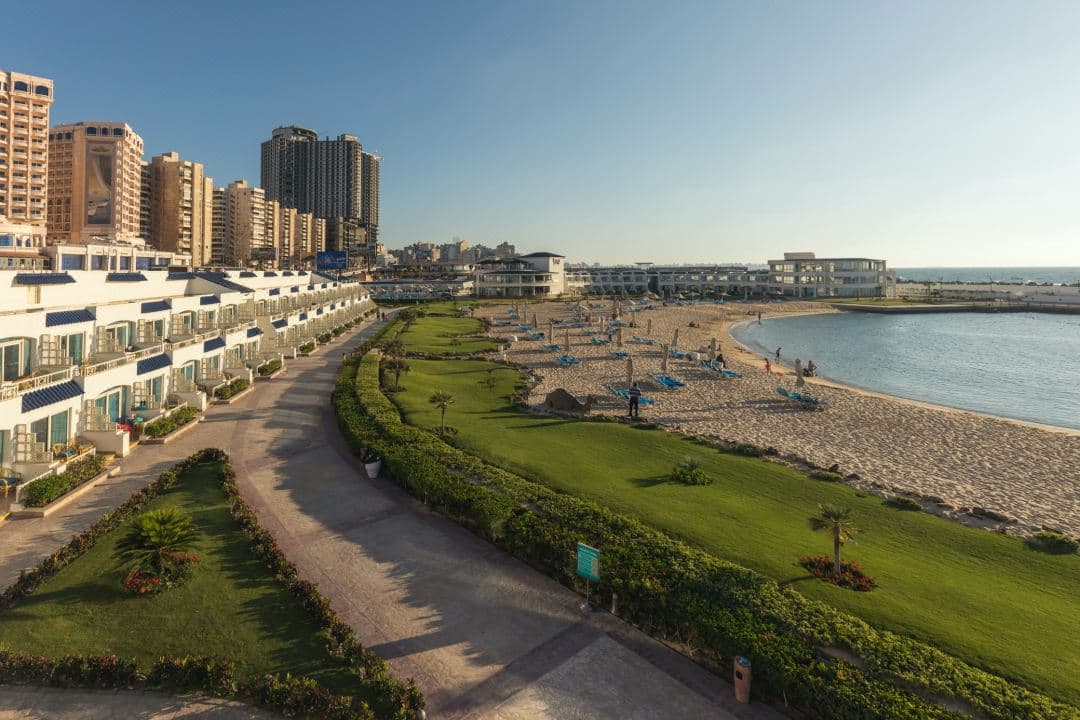 View from a balcony at SUNRISE Alex Avenue Hotel overlooking the Mediterranean Sea and Alexandria Corniche at dusk.