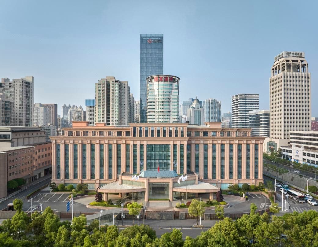 The imposing, symmetrical Soviet-style façade of Hongshan Hotel Wuhan lit up at night, facing the expansive Hongshan Square.