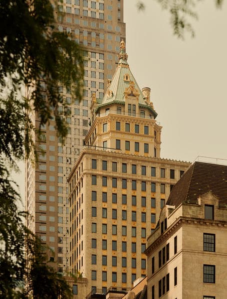 Aman New York's 65-foot indoor pool lined with fire pits and daybeds, reflecting warm ambient lighting.