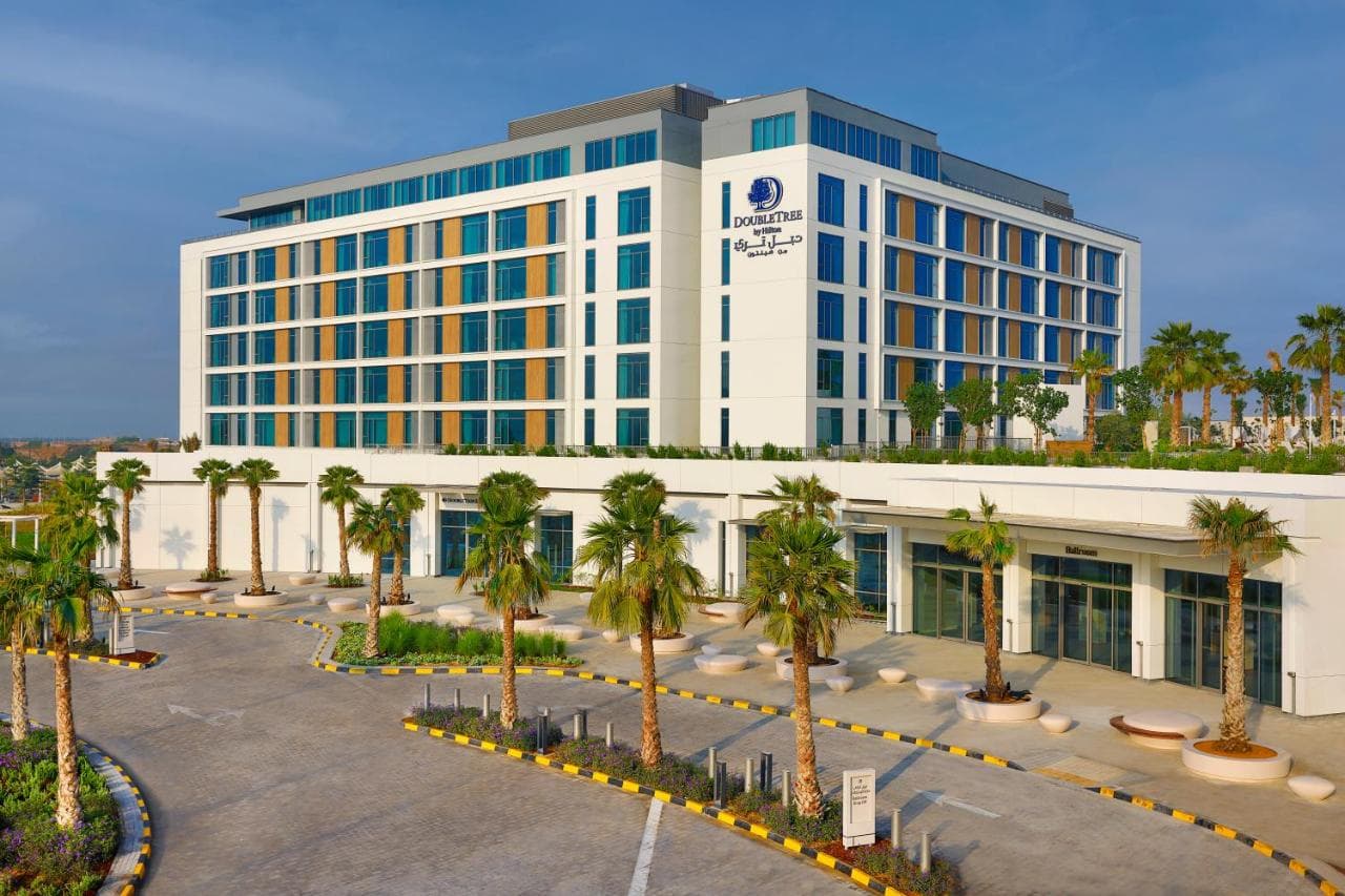Exterior view of DoubleTree by Hilton Abu Dhabi Yas Island Residences showing the modern facade and outdoor pool area.