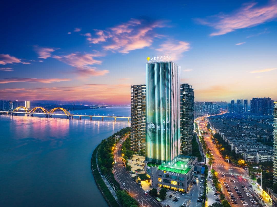 A vast, sun-drenched indoor olympic swimming pool at Empark Grand Hotel Changsha with floor-to-ceiling windows.