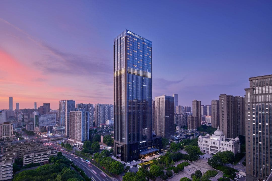 The 33rd-floor indoor pool at JW Marriott Changsha featuring a mirrored ceiling reflecting the city skyline and blue water.