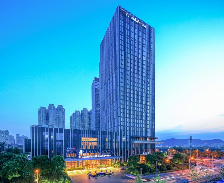 A sweeping view of the Xiang River from a high-floor suite at Wanda Vista Changsha, featuring floor-to-ceiling windows and plush beige interiors.