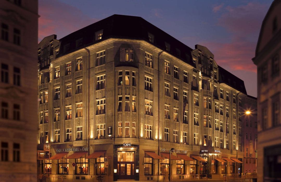 The grand interior of Café Imperial in Prague featuring elaborate Art Nouveau ceramic tiled pillars and mosaic ceilings.