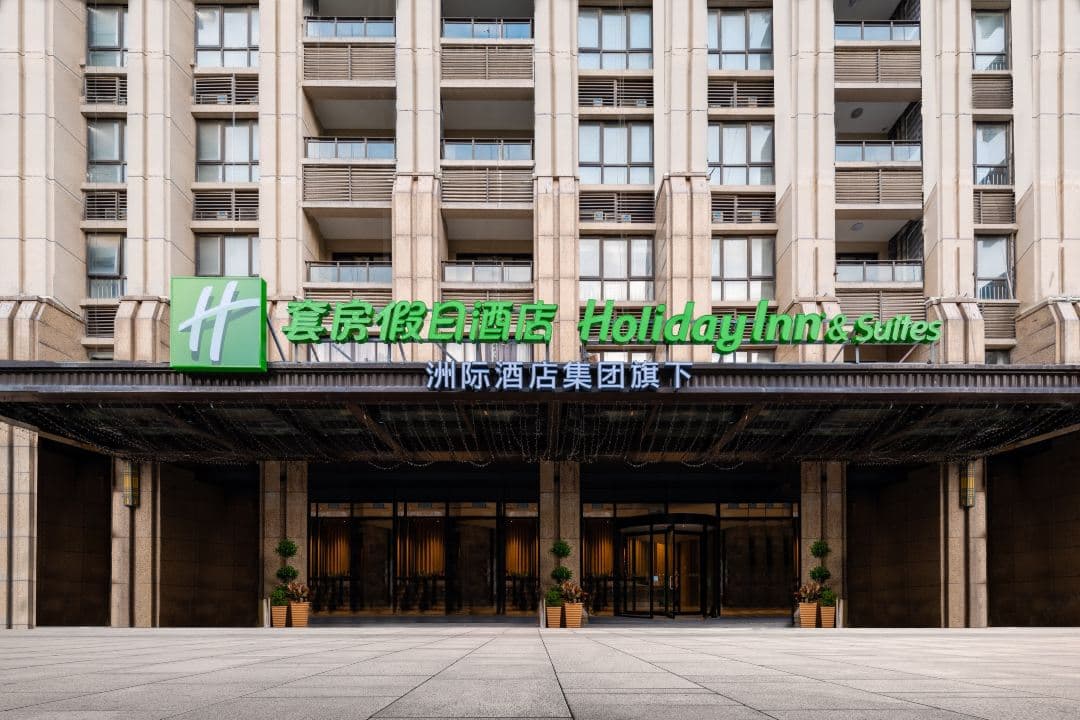 Geometric facade of Holiday Inn Suzhou suites with private balconies overlooking the courtyard.