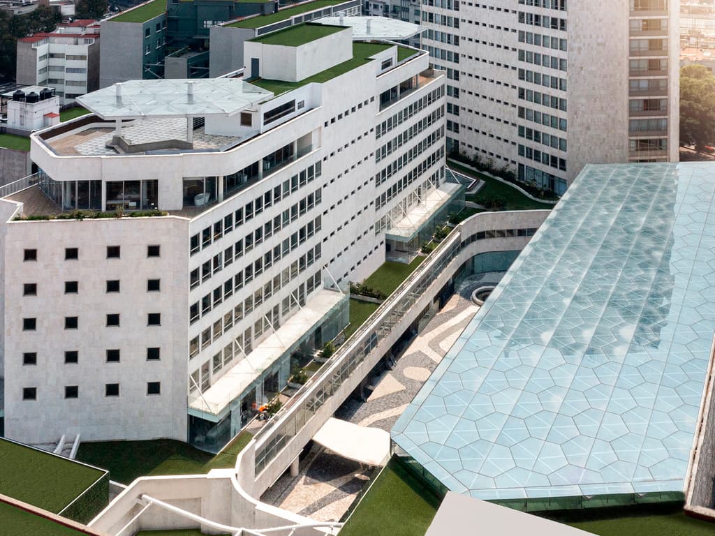 아르데코 인테리어 내에 벨벳 호박색 섹셔널 소파와 현대 미술품이 배치된 Mondrian Mexico City Condesa 로비.