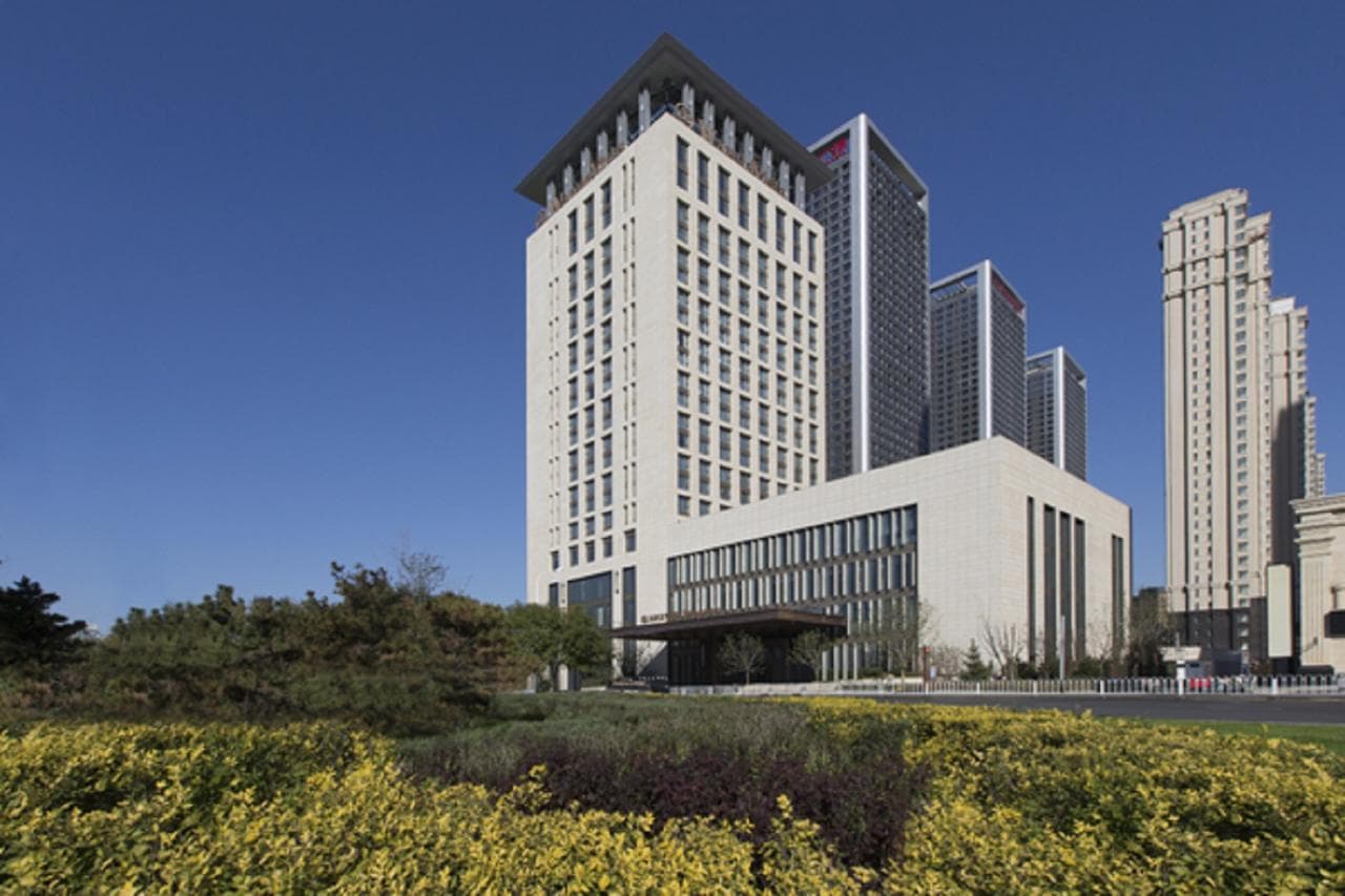 Grand lobby of Wanda Vista Shenyang featuring nine towering crystal dragon pillars and intricate marble flooring.