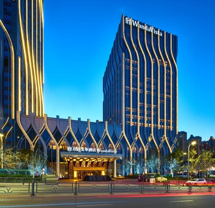 A massive crystal chandelier shaped like a Snow Lotus hanging in the opulent lobby of the Urumqi R&F Wanda Vista Hotel.