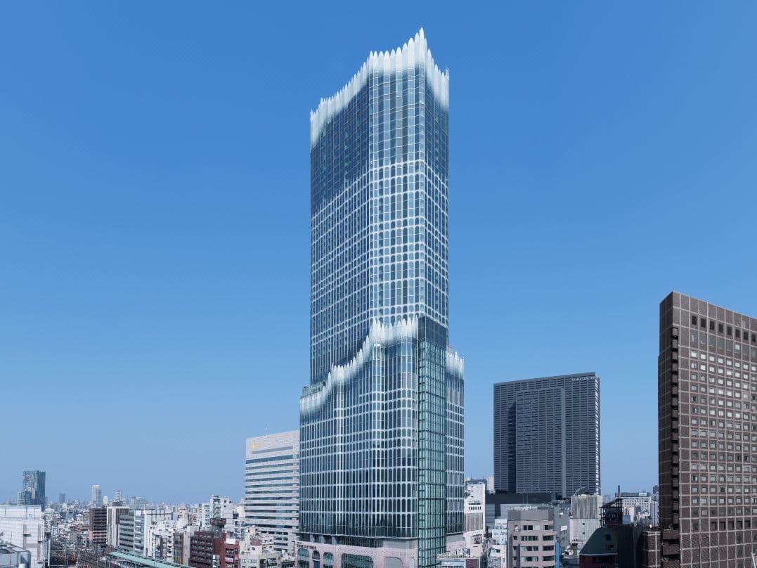A dramatic dusk view from a Bellustar Tokyo suite, featuring a deep soaking tub against a floor-to-ceiling window overlooking the glittering Shinjuku skyline and distant Mt. Fuji.