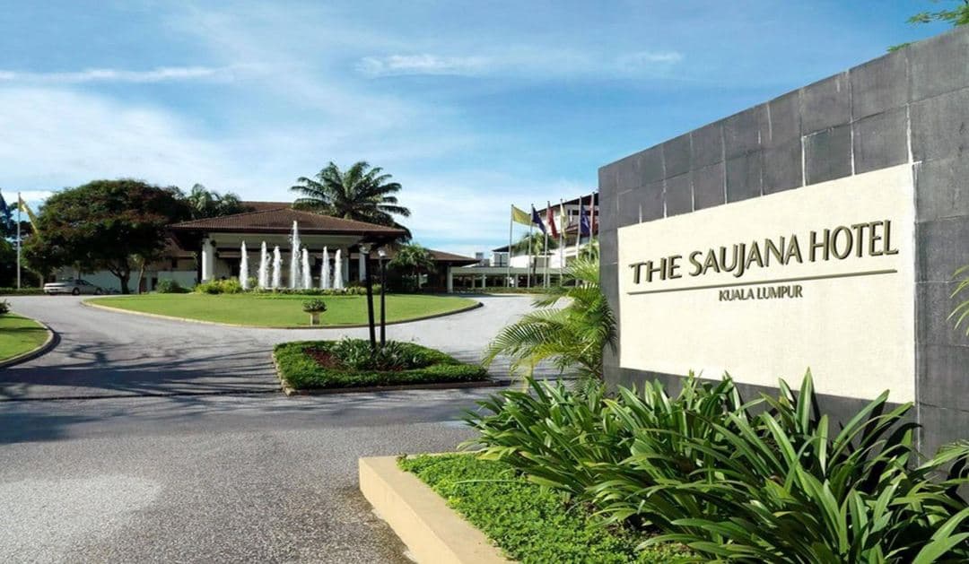 The glass pavilion of Senja restaurant glowing warmly against the twilight reflection of the lake at The Saujana Hotel.