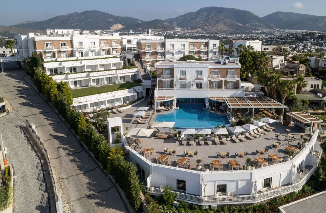 Doria Hotel Bodrum 无边泳池俯瞰 Gumbet 湾，白色建筑风格。