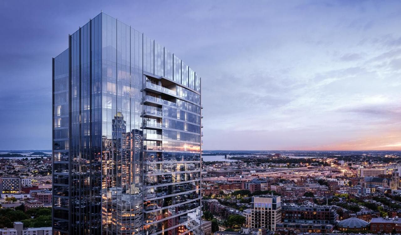 The dramatic three-story spiral staircase in the Raffles Boston Sky Lobby with floor-to-ceiling city views.