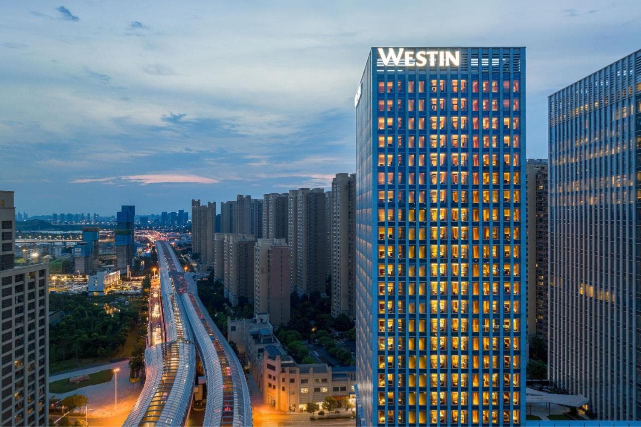 The minimalist indoor heated pool at The Westin Wuhan Hanyang, featuring calm water reflections and floor-to-ceiling city views.