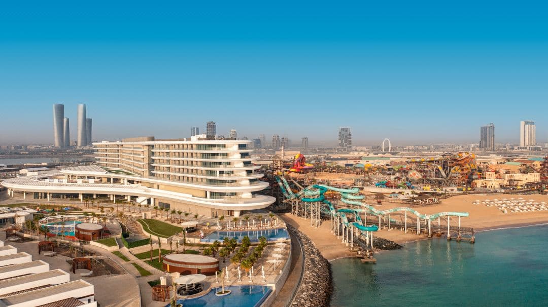 Rixos Premium Qetaifan Island North pool deck featuring the massive Rig 1938 waterpark tower in the background.
