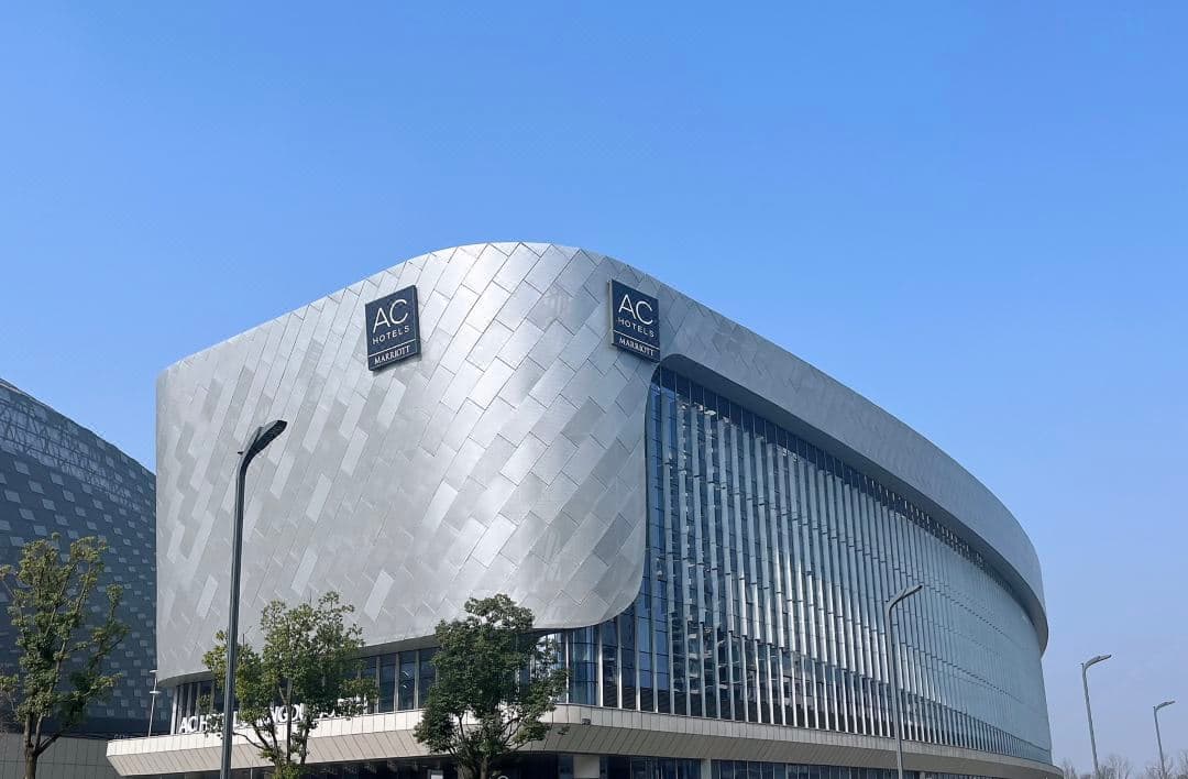 成都北天投AC酒店受蜀锦启发的流线型外观，矗立在凤凰山体育公园旁。