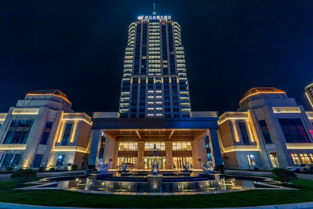 A sleek indoor swimming pool at Grand New Century Hotel Changxing with floor-to-ceiling windows and lounge chairs.