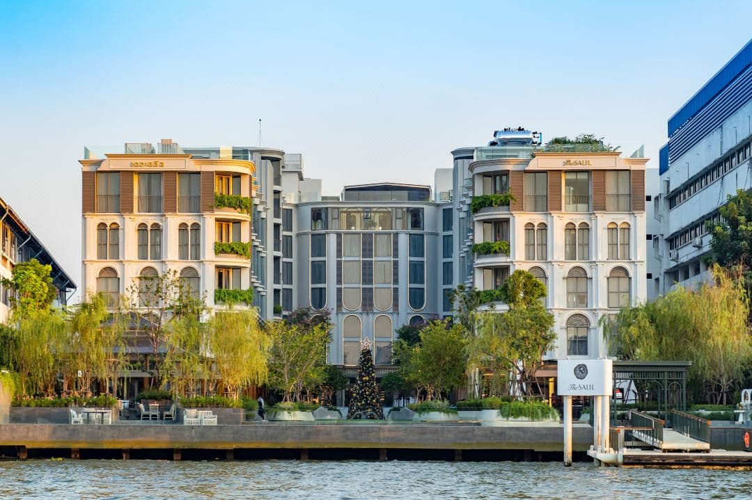 The Salil Hotel Riverside Bangkok courtyard pool surrounded by industrial-chic white arches and vertical gardens.