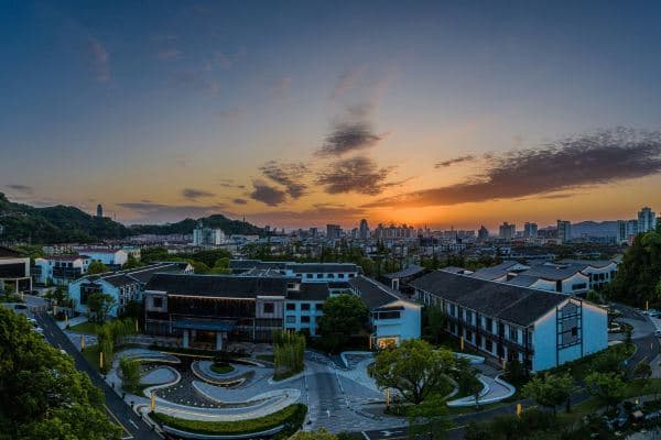 A serene central water courtyard at S&N Phoenix Villa Taizhou at dusk, featuring traditional Chinese pavilions and reflection pools.