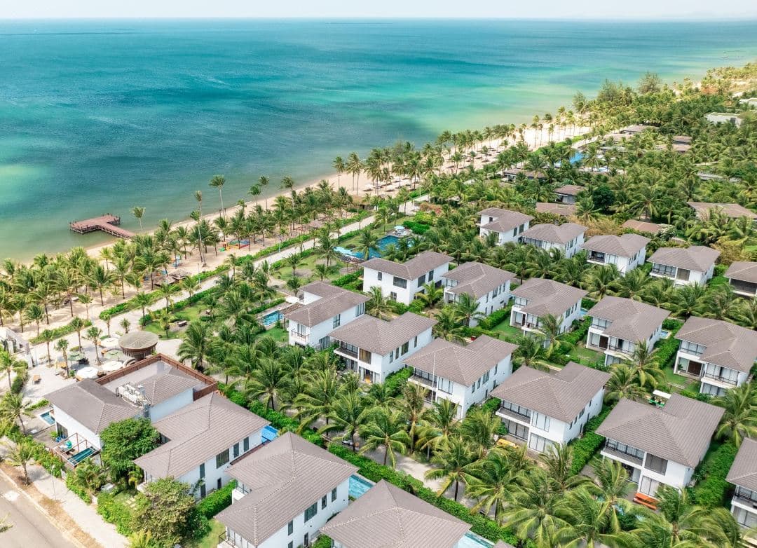 Andochine Resort Phu Quoc beachfront villa with private pool at sunset, featuring dark wood Indochine architecture.