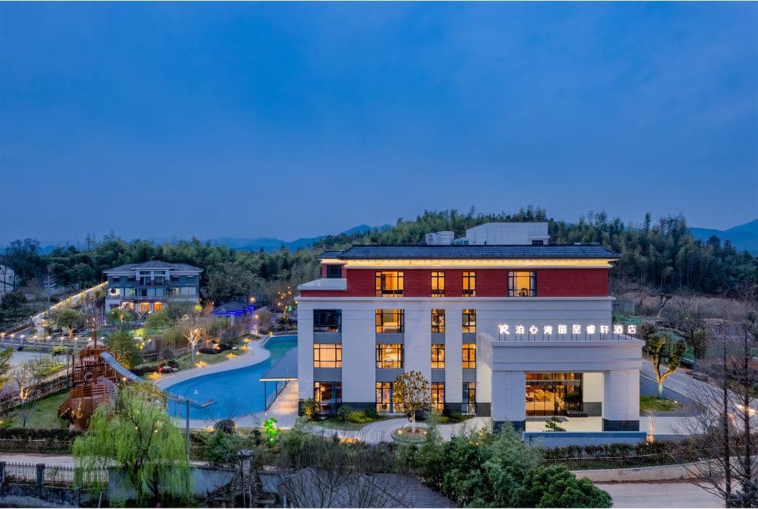 Wooden boat-house style villas at Rezen Select Huzhou Boxin Bay floating amidst a bamboo forest with steam rising from outdoor hot spring pools.