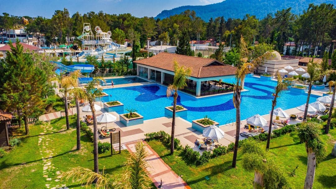 A serene, pine-shaded Silent Pool at Champion Holiday Village reflecting the surrounding forest, with no high-rise buildings in sight.