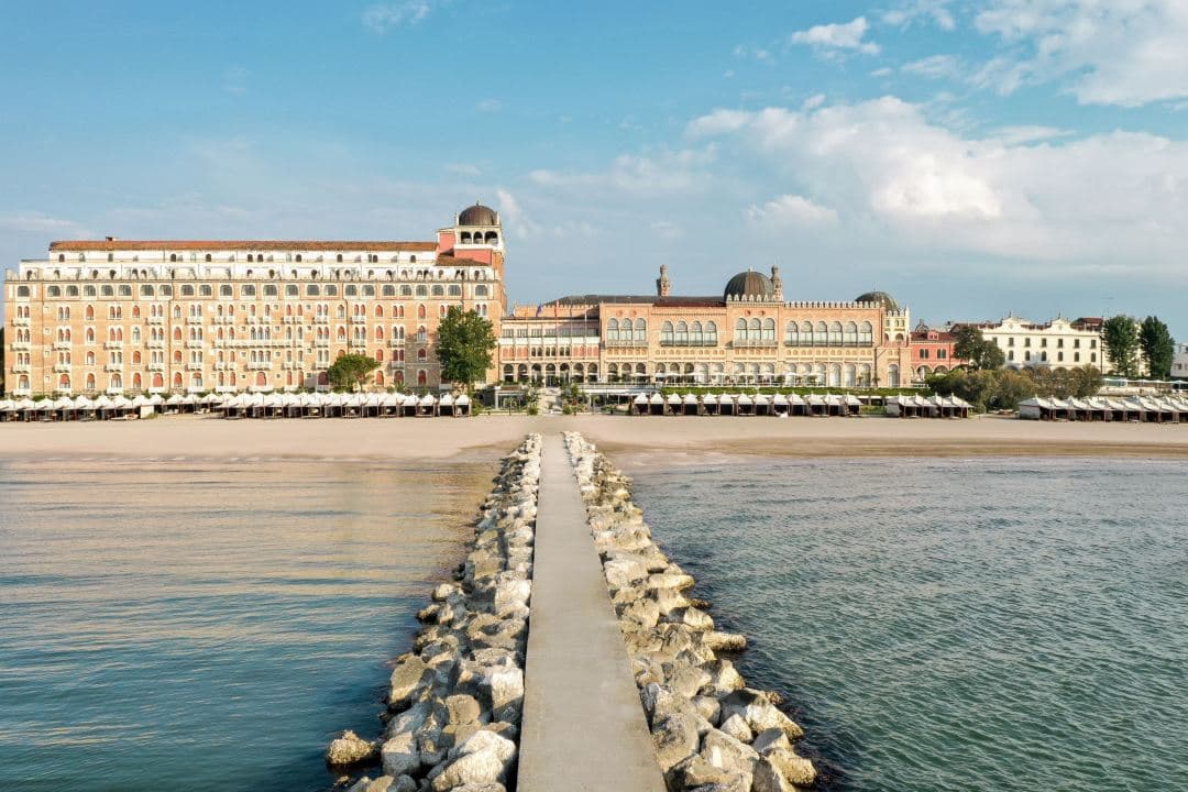 The Hotel Excelsior Venice Lido Resort's iconic Moorish facade and swimming pool overlooking the Adriatic Sea.