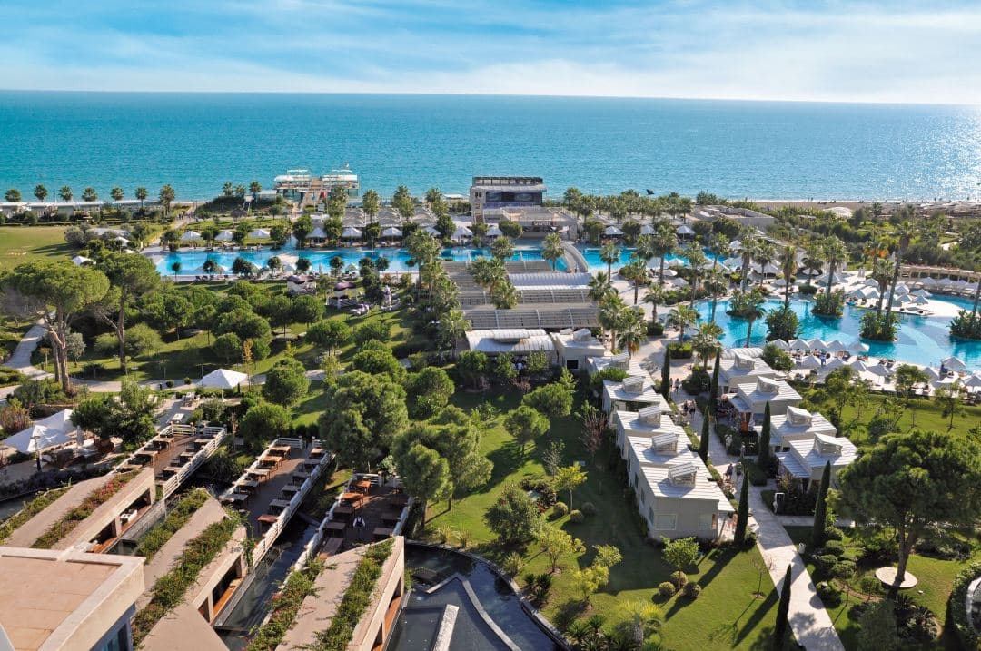 夕暮れ時のSusesi Luxury Resortの空撮。広大なメインプールと、プールに直結したレイクハウスのテラスが特徴的。