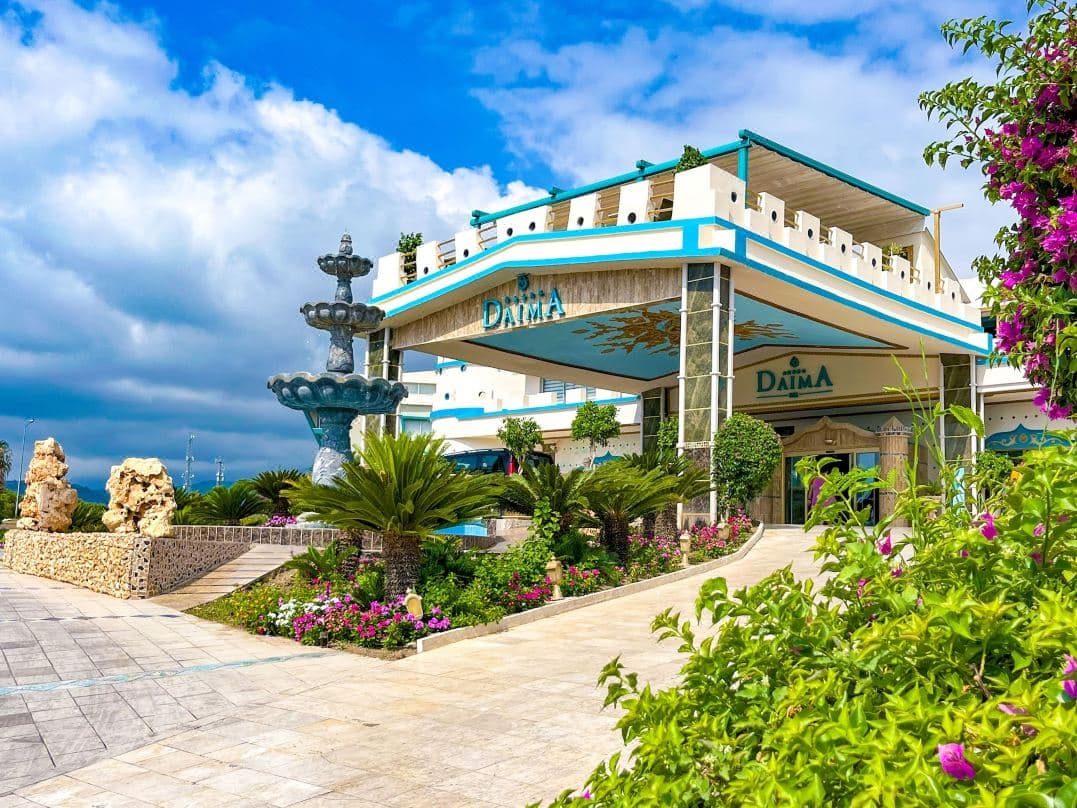 A dramatic view of the Slip N Fly water slides at Dolusu Aquapark with the Mediterranean sea in the background.