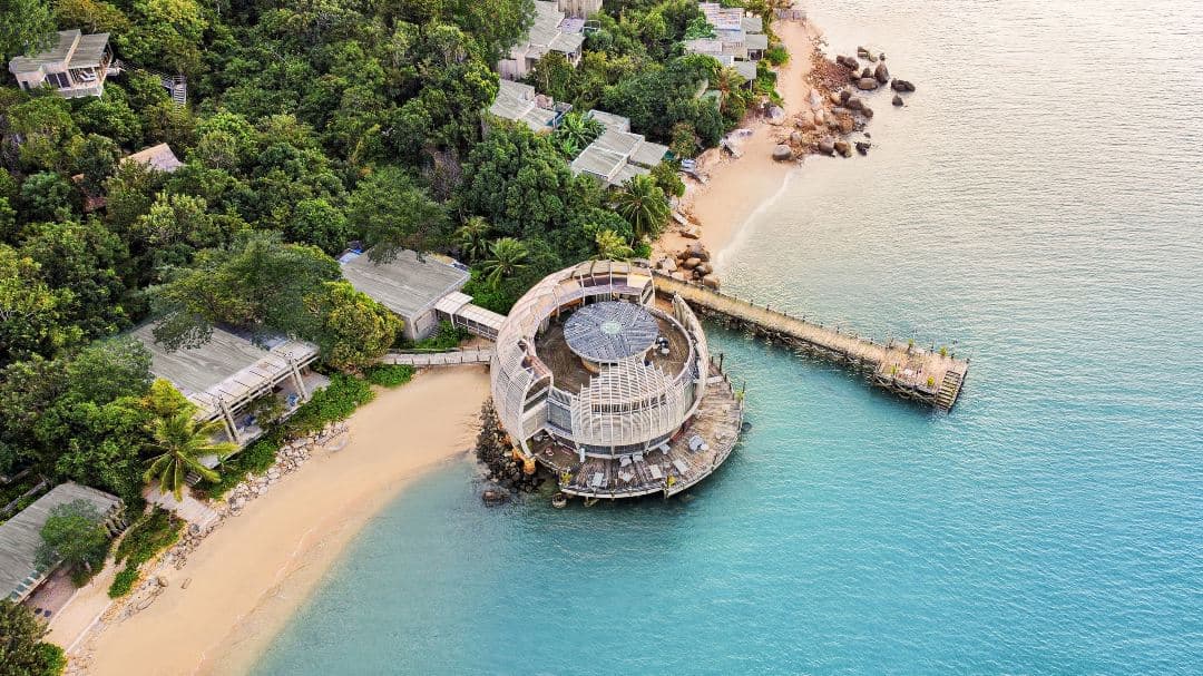 The wooden lotus-shaped Sen Restaurant at An Lam Retreats floating on Ninh Van Bay at twilight.