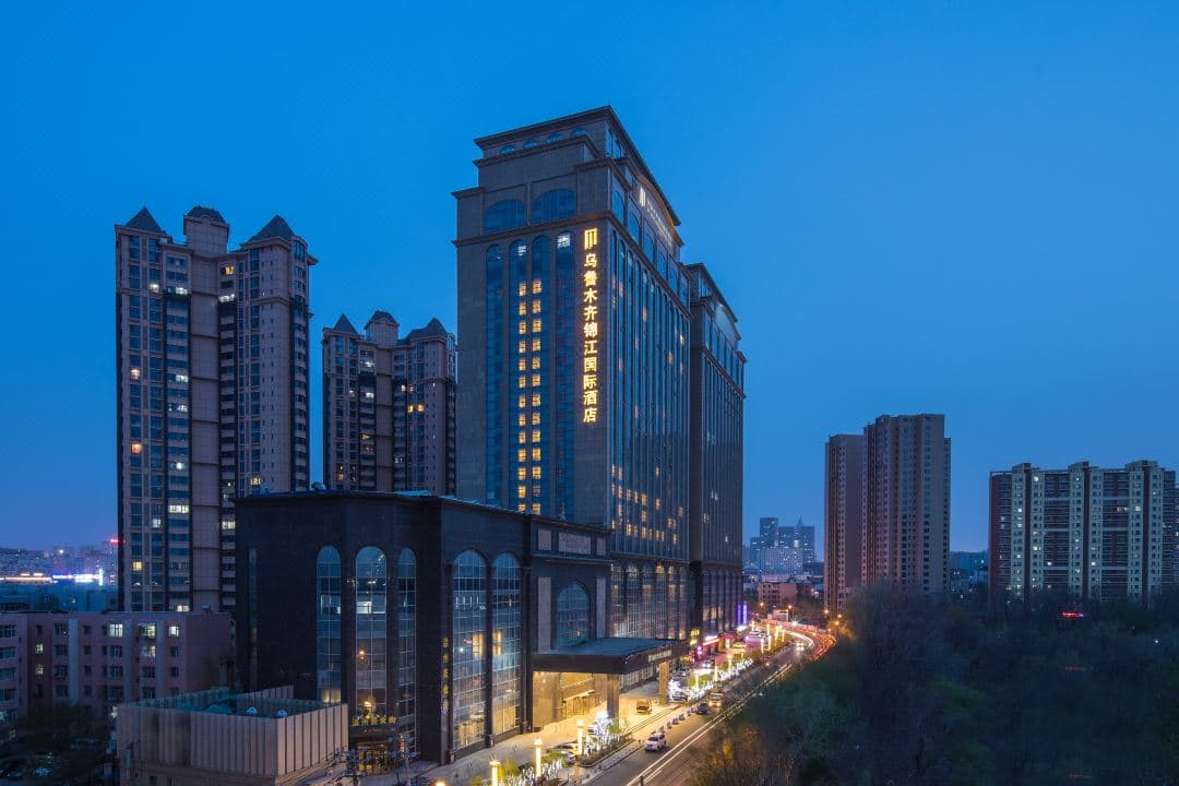 A massive indoor swimming pool with a dramatic glass skylight roof at Jin Jiang International Hotel Urumqi.
