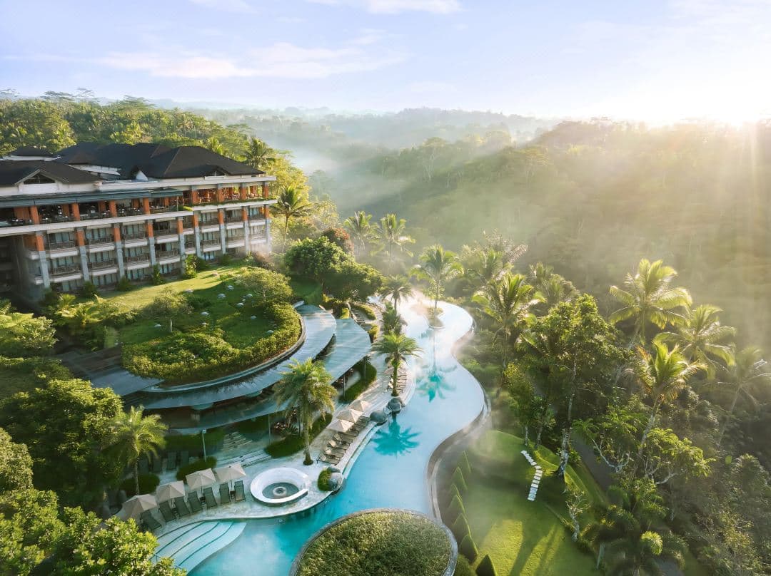 Expansive 89-meter heated infinity pool at Padma Resort Ubud steaming gently against a backdrop of misty Payangan jungle and bamboo forests.
