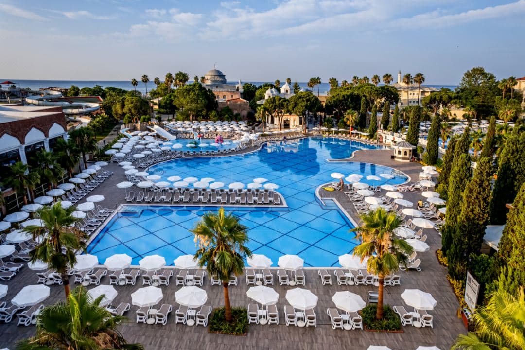Swandor Topkapi Palaceのプールエリア全景。背景には正義の塔のレプリカとオスマン様式のドームが見える。