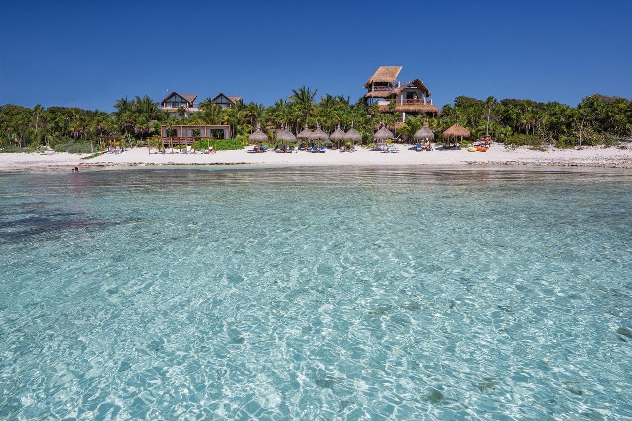 Jashita Hotel's adult infinity pool overlooking Soliman Bay with white loungers and palm trees.