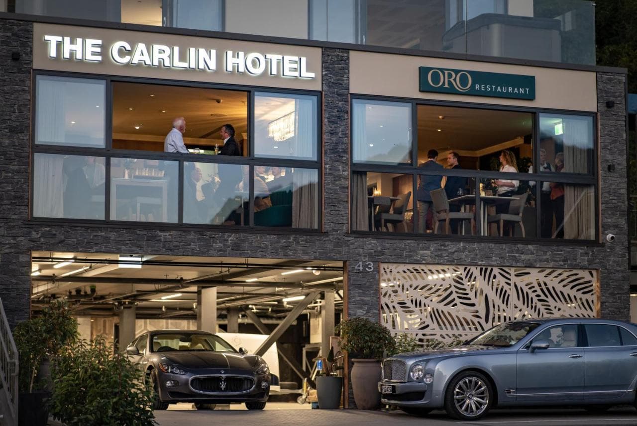 The Carlin Hotel 宽敞的私人露台，配有燃气火坑和 Atmosphera Pipe 扶手椅，背景是瓦卡蒂普湖和卓越山脉的迷人暮色。