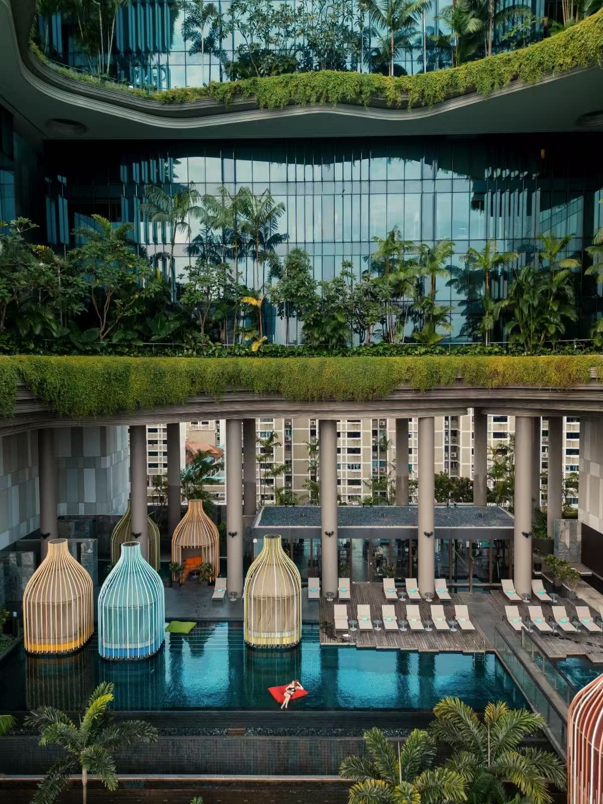 Exterior view of PARKROYAL COLLECTION Pickering showing contoured podium layers overflowing with tropical plants and vertical gardens.