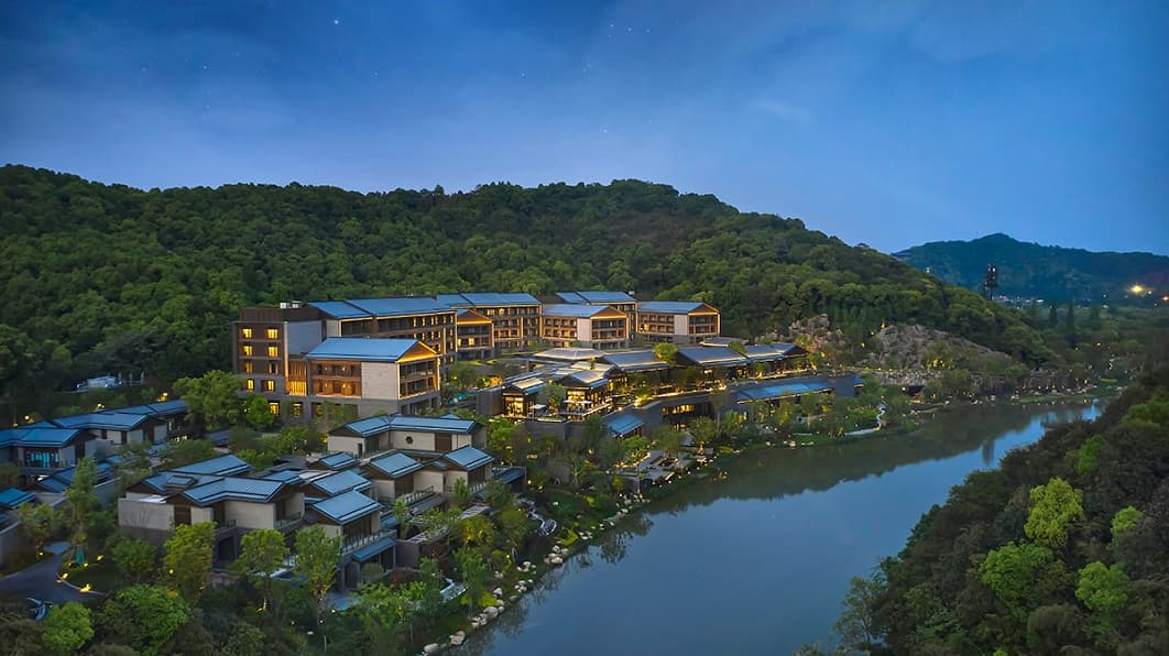 Spacious luxury room at Xianghu Xiaoyao Manor with modern amenities and large windows in Hangzhou.