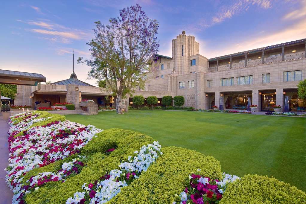 The adults-only Saguaro Pool at Arizona Biltmore surrounded by yellow umbrellas and textile block architecture.