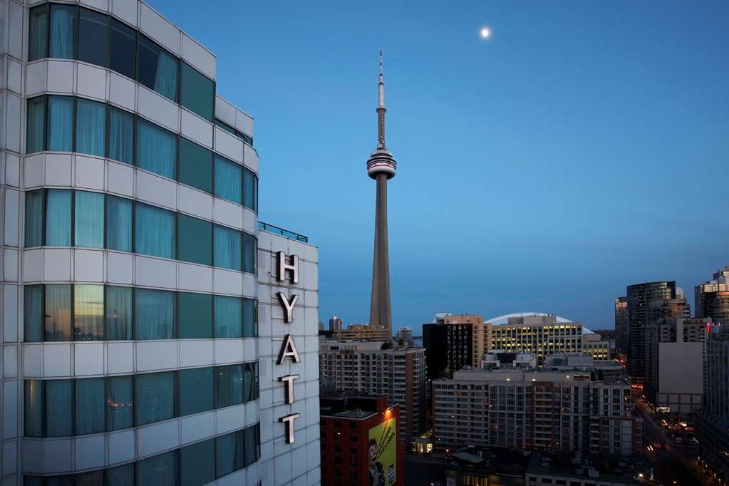 Rooftop pool deck at Hyatt Regency Toronto with guests lounging and the CN Tower prominent in the background.