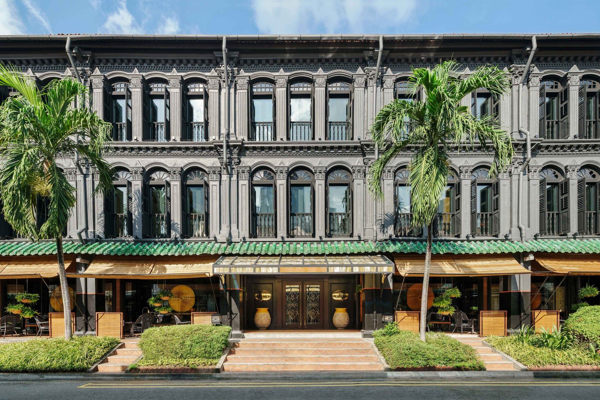 Duxton Reserve Singapore lobby featuring Anouska Hempel's signature black and gold design with large yellow fans and calligraphy screens.